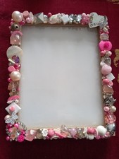 A Photo Frame With Shells Surrounding.