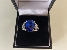 BEAUTIFUL SILVER PLATED BLUE STONE DRESS RING SIZE  Q HEARTS AT THE SIDES