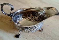 George 3rd Antique Silver Cream Jug with embossed decoration on 3 paw feet.