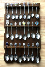 Wooden spoon rack containing 24 collectable ornamental spoons, many silver plate