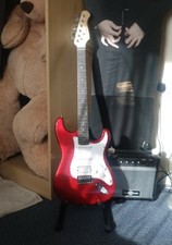Red Electric Guitar with guitar case and strap.
