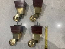 Solid brass reproduction casters with wood support. Approx 15 cm high 