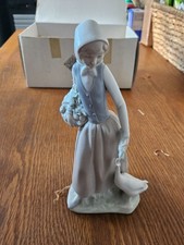 neo lladro Girl with fruit basket, feeding a goose figurine.