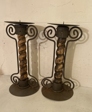 A rustic pair of wrought iron and wooden barley twist candle holders