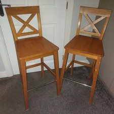 A pair of solid oak cross-back kitchen/breakfast bar stools.