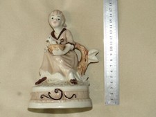 Statue (porcelain?) - Girl with bird & basket - 17.5cm tall, 10.5cm by 11cm base