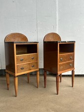 A pair of amboyna veneered bedside cabinets with black marble tops