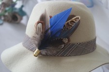 feather and bullet brooch, hat