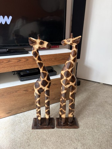 Two wooden giraffe - statues, in