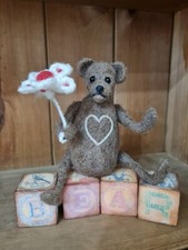 Ooak needle felted bear with glass eyes and clay nose holding a flower