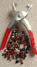 Eyelet pliers with 142 various coloured eyelets.