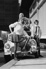 Models wearing driving outfits next to a Mini Cooper S 1966 4x6 PHOTO