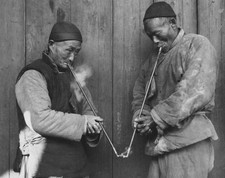 Two elderly men smoking pipes