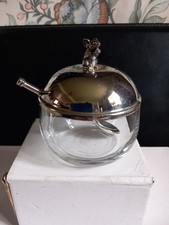 A Glass Jam Pot With A Metal