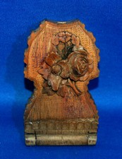 A carved wooden pocket watch