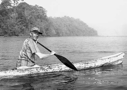 Man paddles dugout canoe at - man,
