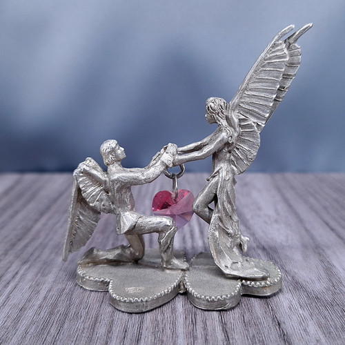 Pewter fairies holding - holding, a