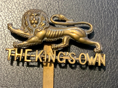 Kings own regiment cap badge - own,