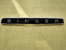SINGER BADGE EMBLEM SCRIPT NOS CHROME FACIA & BLACK BACKGROUND
