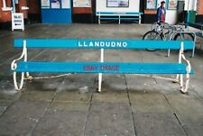 PHOTO  LLANDUDNO  RAILWAY STATION A BENCH IN ARRIVA TRAINS WALES COLOURS AT LLAN
