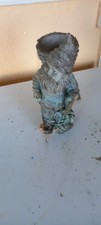 Weathered Gnome With A Basket On His Back Carrying A Stick