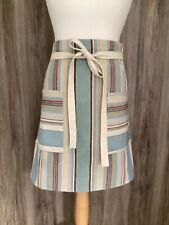 Wide half apron with two pockets and long straps in 100% cotton fabric. Stripes.