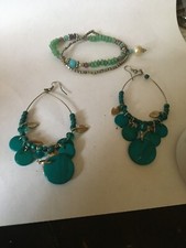 ear rings green dangling . and elasticated bracelet