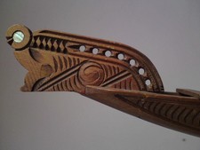 Carved small wooden model of Maori waka taua (war canoe) with Paua shell inlaid
