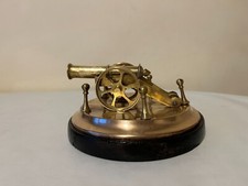 Vintage brass cannon ornament on wooden base