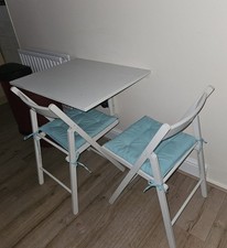 White IKEA wall-mounted drop-leaf table (74x60) with 2 white folding chairs