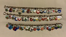 VINTAGE LARGE COLLECTION OF 62 TRAVEL CHARMS ON THREE SILVER CHARM BRACELETS