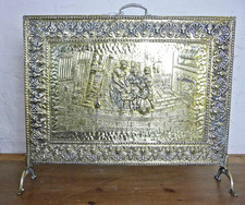 VINTAGE BRASS FIRESCREEN WITH EMBOSSED IMAGE OF PEOPLE DINING