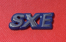 SXE  - VINTAGE METAL CAR BADGE -  50 X 22MM  - VGC