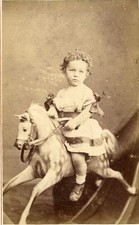 Young girl sitting on rocking horse cdv photo