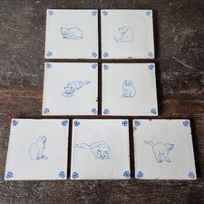 Seven late 19th century delft cat tiles.