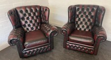 A pair of ox blood red leather chesterfield  wing back chairs 