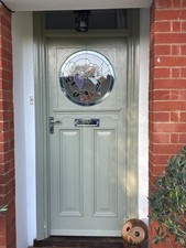 Original 1930s front door featuring a round stained glass window.