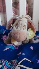 Grey Eeyore holding a flower