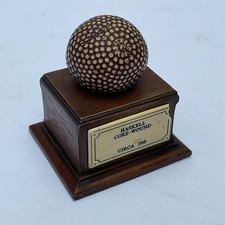 Haskell Core- Wound Golf Ball Paperweight Ornament on a wooden stand with plaque
