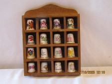 THIMBLE HOLDER WITH 16 CHINA THIMBLES DEPICTING FLOWERS.