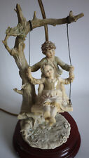 FLORENCE LAMP WITH PORCELAIN FIGURINE BOY & GIRL ON SWING SIGNED B. MERLI 1983