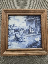 Framed Delftware tile depicting a Dutch scene of sheep shearing.