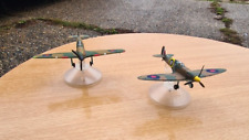 2 x World War II Die cast aeroplane models. Spitfire and Hurricane. On plinths.