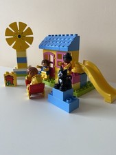 Lego Duplo house with slide scene and assorted figures.