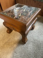 Carved Wooden Coffee Table With A Glass Top Covering Wooden Carving