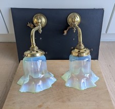 pair of vintage vaseline glass shades on matching vintage brass gas brackets.