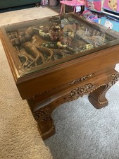 Carved Wooden Coffee Table With A Glass Top Covering Wooden Carving