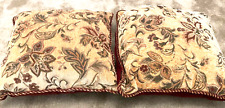 A pair of cushions in metallic gold with deep red pattern.