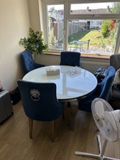Round Glass dining table with four blue chairs