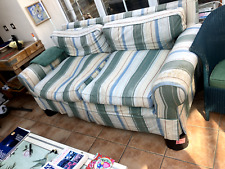 worn large sofa with blue and white striped cover 